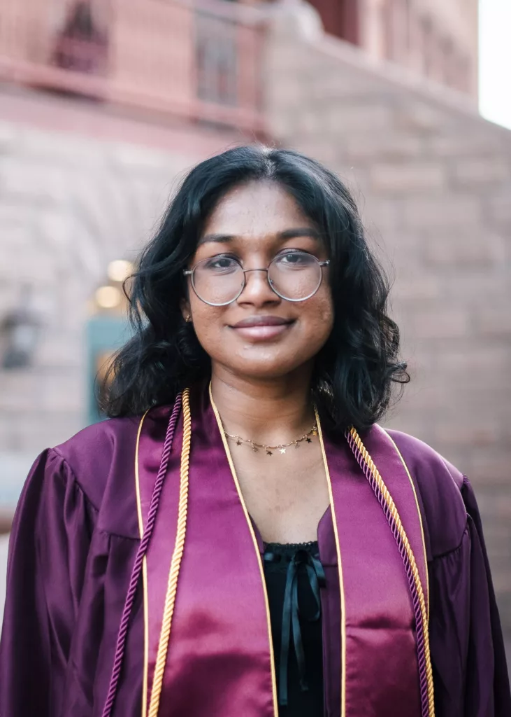 Shrada smiling in her down at graduation.
