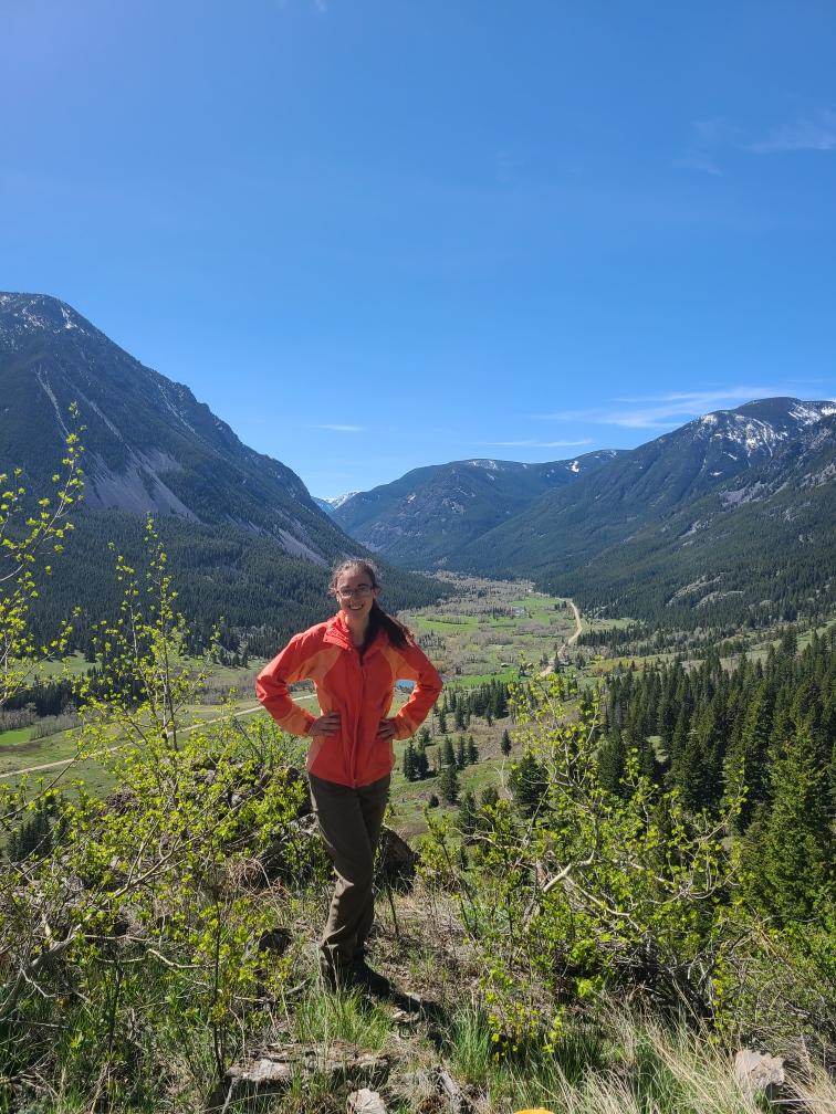 URISE intern Anah smiling with mountains in the background.
