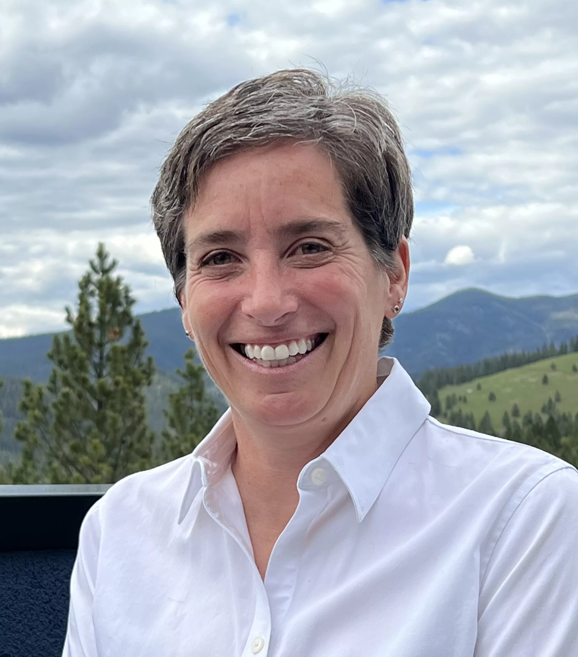 photo of woman outside, clouds and hills in background