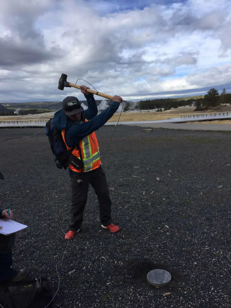 A person holding a sledgehammer about to produce an active source shot