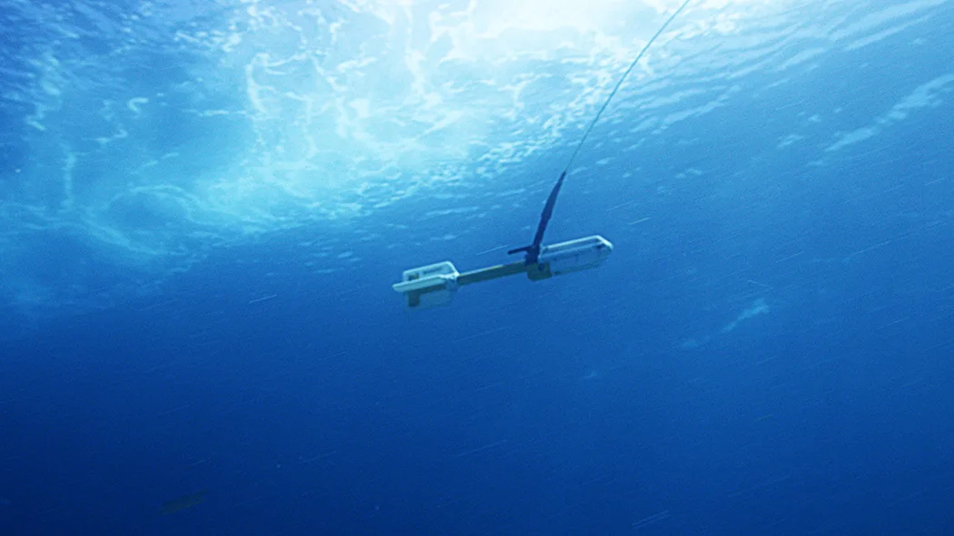 White and yellow magnetometer being towed through the water. 