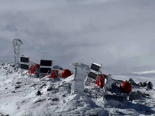 An image of geophysical equipment on an icy, windswept ridge.